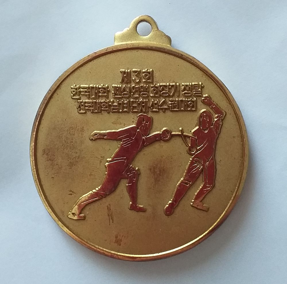 M�daille d'escrime dor�e (texte en langue asiatique) date 1984-12-1 20 Montauban (82)