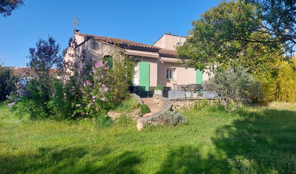 Maison avec vaste terrain arboré, garage et sous-sol